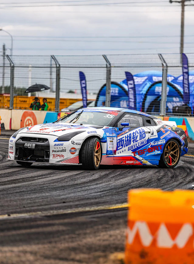 Kicking up tire smoke, the West Lake Tire-TTSPORT Racing team's Nissan GTR executes a high-angle drift on the racetrack.